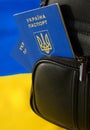 Ukrainian passport in a backpack against the background of the Ukrainian flag. Immigration of people in connection with the war