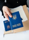 Ukrainian passport in hand on the background of documents. Passport of a citizen of Ukraine. Inscription in Ukrainian