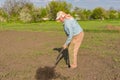 Ukrainian peasant digging up with pitchfork in kitchen garden Royalty Free Stock Photo