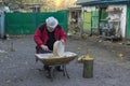 Ukrainian peasant doing daily work clean sieve sitting on ancient stool Royalty Free Stock Photo