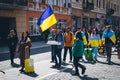 Ukrainian people walk with Ukrainian flags on the street.