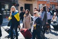 Ukrainian people walk with Ukrainian flags on the street. Peaceful demonstration of Ukrainian refugees.