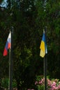 Ukrainian and Russian flags are waving in the wind on flagpoles. Political situation between Ukraine and Russia. The concept of Royalty Free Stock Photo