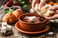 Ukrainian and Russian traditional beetroot soup or borscht in bowl with rib eye meat, buns, parsley on wooden rustic background. Royalty Free Stock Photo