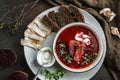 Ukrainian and Russian traditional beetroot soup - borscht in bowl with rib eye meat, rye bread, slices of bacon and sour cream on Royalty Free Stock Photo