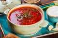 Ukrainian and Russian traditional beetroot soup - borscht in bowl with sour cream, garlic, herbs and bread on wooden background Royalty Free Stock Photo