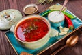 Ukrainian and Russian traditional beetroot soup - borscht in bowl with sour cream, garlic, herbs and bread on wooden background Royalty Free Stock Photo