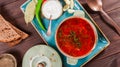 Ukrainian and Russian traditional beetroot soup - borscht in clay pot with sour cream, bread on dark wooden background Royalty Free Stock Photo