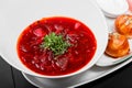 Ukrainian and Russian traditional beetroot soup - borscht in plate, sour cream and buns with garlic and herbs on dark background Royalty Free Stock Photo