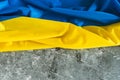 Ukrainian satin flag. Waving fabric texture flag of Ukraine. Real flag on concrete gray background Royalty Free Stock Photo