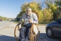 ukrainian senior man sitting in rrocking chair on roadside and holding vacuum bottle