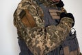 Ukrainian soldier in military pixel unform and bulletproof vest jacket with banner of flag of Ukraine and arm in black glove