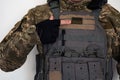 Ukrainian soldier in military pixel unform and bulletproof vest jacket with banner of flag of Ukraine and finger