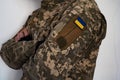 Ukrainian soldier in unform pixel jacket with arms on chest.