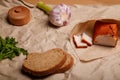 Ukrainian traditional meal. Lard in red pepper, garlic, parsley, rye bread and salt pot on paper. Lunch on farm or cotage house