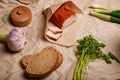 Ukrainian traditional meal. Lard in red pepper, onions, garlic, parsley, rye bread and salt pot on paper. Lunch on farm or cotage