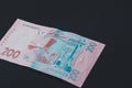 Ukrainian two hundred hryvnia lie on the back on a black isolated background Royalty Free Stock Photo