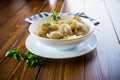 Ukrainian Vareniky or Pierogi stuffed with potato and mushrooms, served with fried onion. Wooden table background