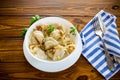Ukrainian Vareniky or Pierogi stuffed with potato and mushrooms, served with fried onion. Wooden table background
