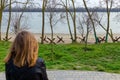 Ukrainian woman back to camera looking at czech hedgehogs on river bank of peaceful town. Military invasion of Russia, war in