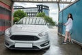 Ukrainian woman  with foam water gun cleans her car in service Royalty Free Stock Photo