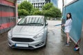 Ukrainian woman  with foam water gun cleans her car in service Royalty Free Stock Photo