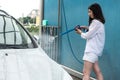 Ukrainian woman  with foam water gun cleans her car in service Royalty Free Stock Photo