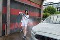 Ukrainian woman  with foam water gun cleans her car in service Royalty Free Stock Photo