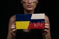 Ukrainian woman holds the inscription stop war in her hands. Painted yellow and blue flag on her face Royalty Free Stock Photo