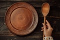 Ukrainian woman sitting in national restaurant and waiting for order. Wooden table, waiting for dish. Empty clay plate