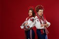 Ukrainian women in traditional ethnic clothing and floral red wreath on viva magenta studio background. National embroidered dress Royalty Free Stock Photo