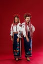 Ukrainian women in traditional ethnic clothing and floral red wreath on viva magenta studio background. National embroidered dress Royalty Free Stock Photo