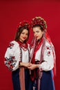 Ukrainian women in traditional ethnic clothing and floral red wreath on viva magenta studio background. National embroidered dress Royalty Free Stock Photo