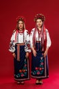 Ukrainian women in traditional ethnic clothing and floral red wreath on viva magenta studio background. National embroidered dress Royalty Free Stock Photo