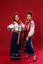 Ukrainian women in traditional ethnic clothing and floral red wreath on viva magenta studio background. National embroidered dress Royalty Free Stock Photo