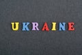UKRAINIAN word on black board background composed from colorful abc alphabet block wooden letters, copy space for ad