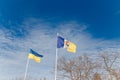 Ukrainian yellow and blue flag and coat of arms of Ukrainian town Izmail flying on blue cloudy sky background