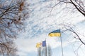 Ukrainian yellow and blue flag and coat of arms of Ukrainian town Izmail flying on blue cloudy sky background