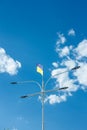 Ukrainian yellow and blue national flag on street lamp fluttering on blue cloudy sky background, vertical shot Royalty Free Stock Photo