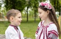 Ukrainian younger boy and older girl, brother and sister, in national Ukrainian embroidered clothes, look at each other Royalty Free Stock Photo