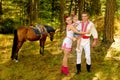 Ukrainians Mom and Dad and daughter in the woods with a horse