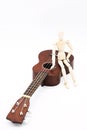 Ukulele acoustic guitar with human mannequin figure . Break time for hobby. Art or musical concept. Royalty Free Stock Photo