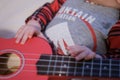 Baby fingers plays guitar. Ukulele strings and frets Royalty Free Stock Photo