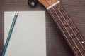 Ukulele in close up with a sheet of paper to write down musical scores. Concept of musical composition and creation. Isolated
