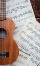 Ukulele guitar on music sheets on wooden background closeup Royalty Free Stock Photo