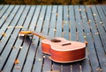 Ukulele guitar on wood table in the garden under the morning sun