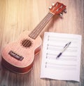 Ukulele and musical paper notes Royalty Free Stock Photo