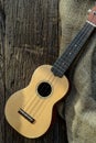 The Ukulele on a rustic table with burlap sacking on wooden back Royalty Free Stock Photo