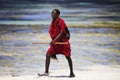 Commercial portrait of young tribal Masai warrior man on hot bright sunny African beach