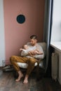 ul family a young dad holds a little son in his arms while sitting in an armchair Royalty Free Stock Photo